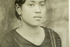 Mulher de roupa cor escura e brincos de argola