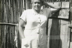 Mulher de cabelo curto apoiada em portão