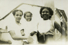 Mulheres de vestido claro com criança de colo