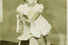 Menina em cavalo de madeira