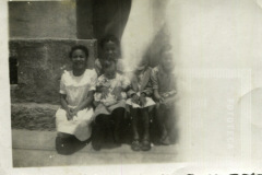 Grupo de crianças sentadas na soleira da porta