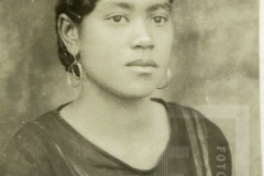 Mulher de roupa cor escura e brincos de argola