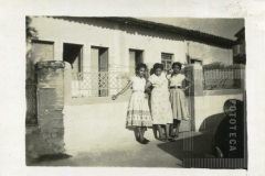 Mulheres em portão de casa