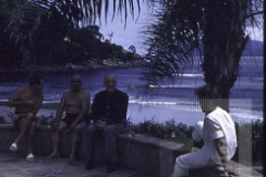 Três pessoas sentadas ao sol