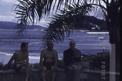 Três homens com mar ao fundo
