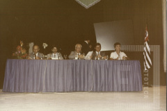 Homens sentados em uma mesa no evento