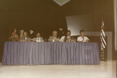 Homens sentados em uma mesa no evento