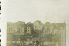 Criança sentada com vista de casas ao fundo