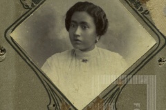 Mulher de roupa clara e brincos redondos